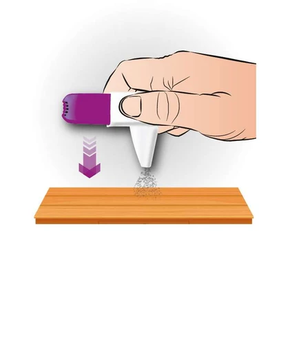Mano umana che tiene un dispositivo bianco-viola dal quale esce un aerosol diretto verso il basso su una superficie di legno, indicato da una freccia viola