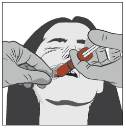 Two gloved hands holding a syringe with red liquid and applying it to the open mouth of a person with closed eyes