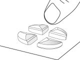 Un dito tocca una delle quattro parti di una compressa divisa, posata su una superficie piana, in un disegno schemático a linee