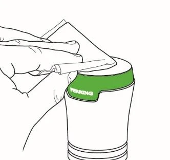 Una mano sostiene una bolsa de papel blanca y vierte cuidadosamente su contenido en un recipiente blanco con una franja verde y la inscripción PERRING