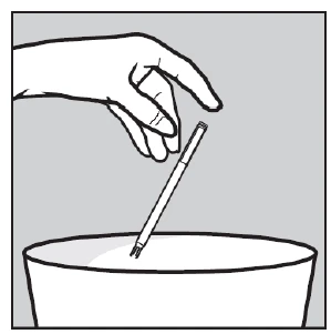 Hand holding a thin syringe with its tip submerged in a white liquid contained in a wide bowl or vessel
