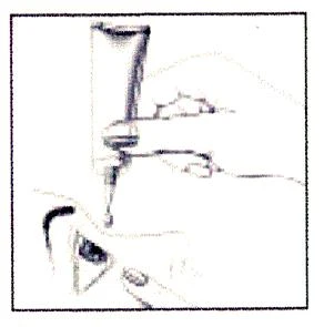 Una mano sta spremendo il contenuto di un tubo direttamente su una parte di pelle, accanto è visibile un frammento dell'imballaggio del farmaco e le dita che tengono il tubo