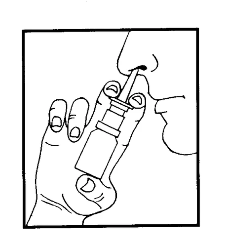 A hand holding a small bottle with an applicator, inserting the tip into a person's nose to administer medication in spray form
