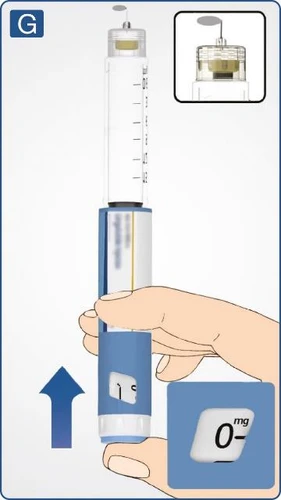 Hand holding a blue-and-white injector with visible dose scale, close-up on the button with the number 0 and the upper part of the device
