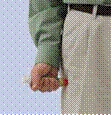 A hand holds a syringe with a red cap, prepared for injection