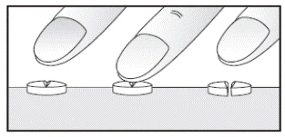 Manos separando una pastilla en dos partes iguales, colocadas sobre una superficie plana, mostrando la forma correcta de dividir los medicamentos