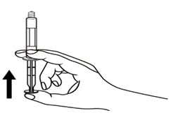 Una mano tiene la siringa verticalmente, le dita premono lo stantuffo verso l'alto, mostrando il senso di somministrazione della soluzione