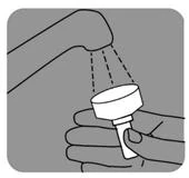 A hand holds a white dosing cup under a stream of water from a tap, rinsing its inner surface