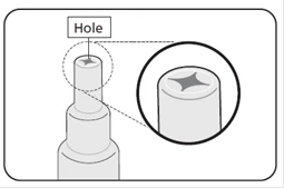 Close-up view of the opening in the bottle cap, magnified to show the star-shaped opening for needle insertion