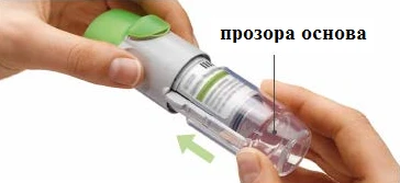 Mani che impugnano un inalatore con base trasparente indicata da una freccia, coperchio verde aperto, visibile la parte interna del dispositivo