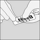 Hands opening a blister pack of tablets, pulling one tablet out with fingers